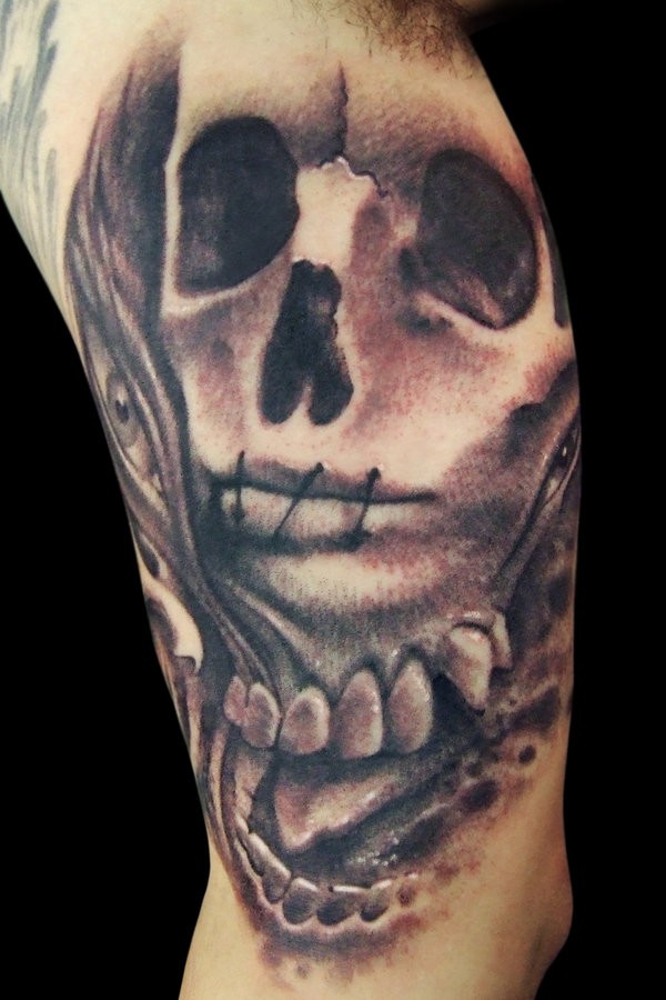 Tatuaje en el brazo, cráneo con la boca cosida