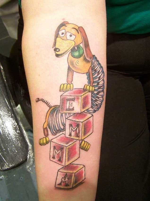Funny cartoon hero dog toy tattoo on forearm with lettering