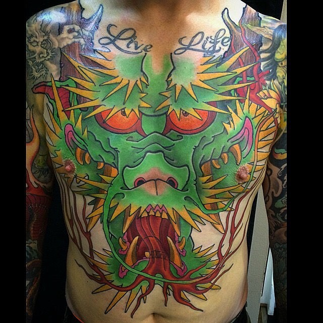 Funny cartoon like colored big dragon tattoo on chest