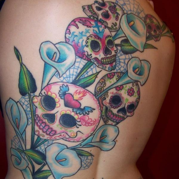 Funny cartoon like Mexican traditional skulls tattoo on back combined with blue flowers