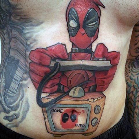 Funny cartoon style colored belly tattoo of Deadpool with video game