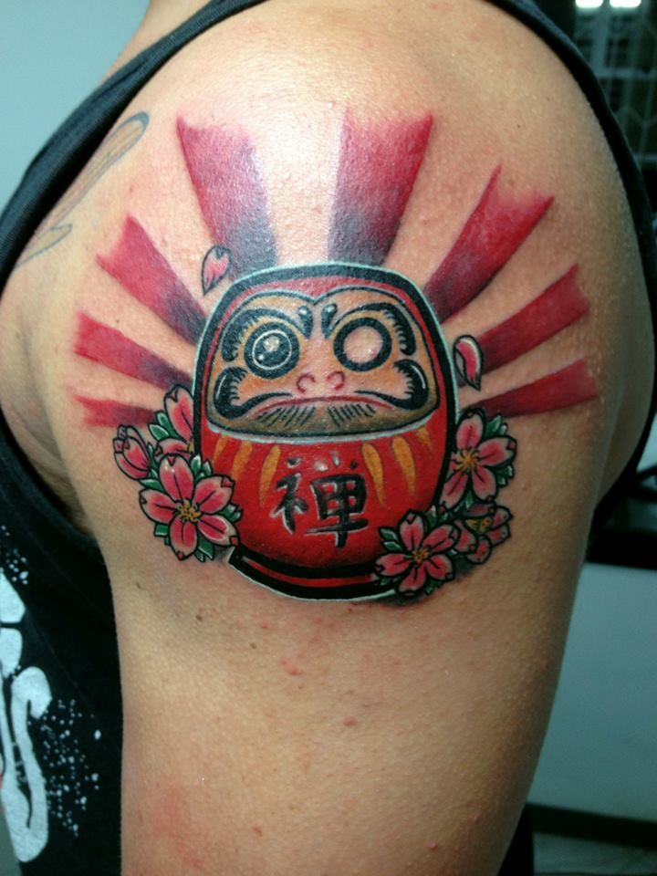 Funny cartoon style colored shoulder tattoo of daruma doll with flowers