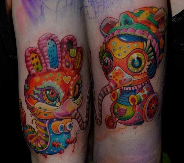 Funny colored arm tattoo of creepy dolls