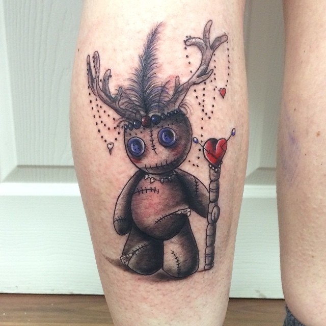 Funny deer like colored leg muscle tattoo of funny voodoo doll with staff