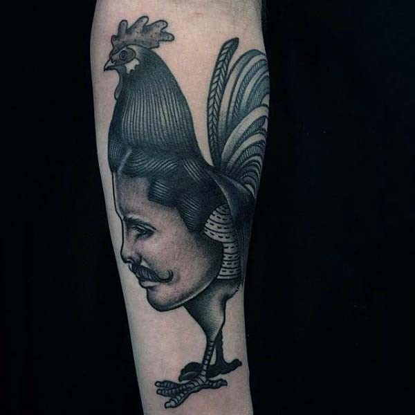 particolare divertente inchiostro nero gallo con faccia umana tatuaggio colorato su braccio
