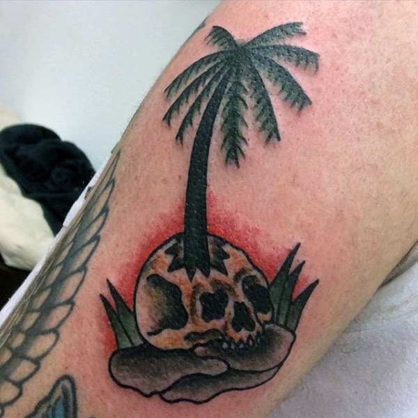 Funny designed little colored palm tree with skull tattoo on arm