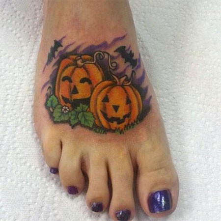 Funny Halloween pumpkins and flying bats colored tattoo on foot