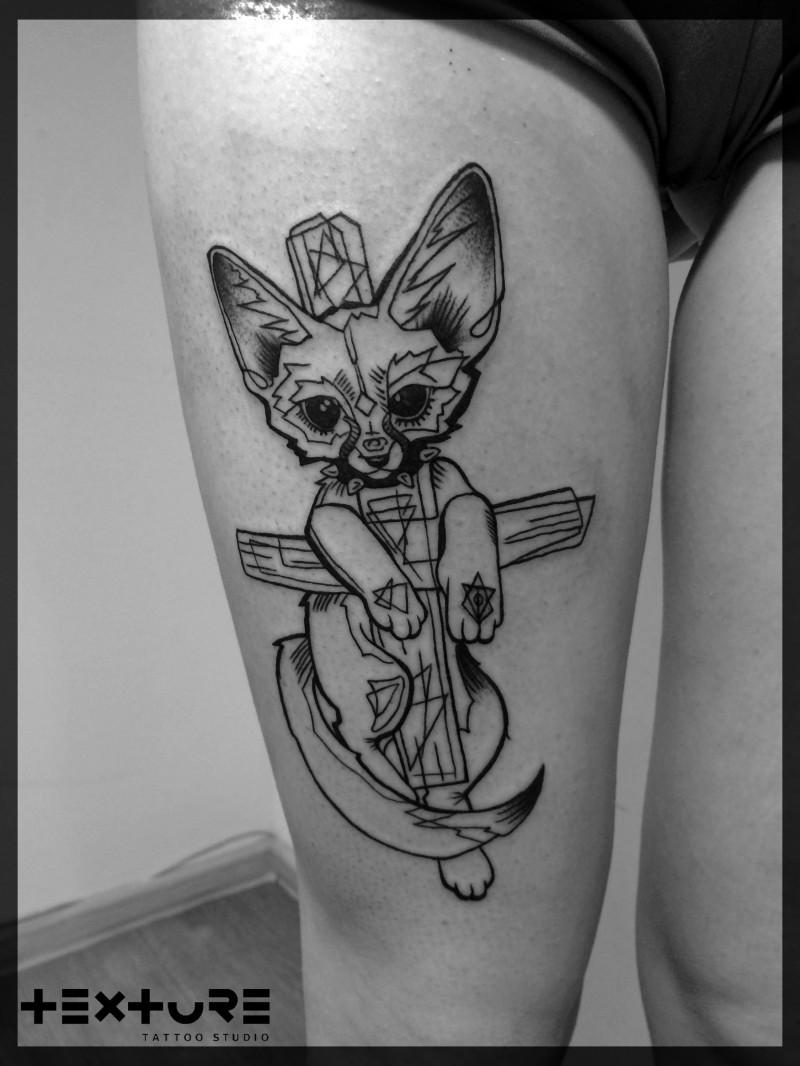 Funny looking black and white thigh tattoo of mystical cat with cross