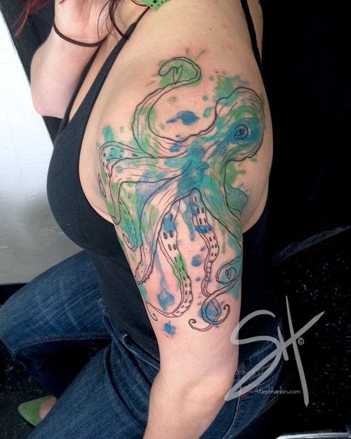 Funny octopus with green and blue paint drips shoulder tattoo in watercolor style