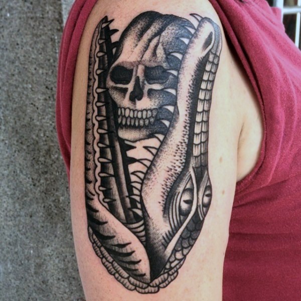 Tatuaje en el brazo,
cráneo en la boca de caimán monstruoso,  old school