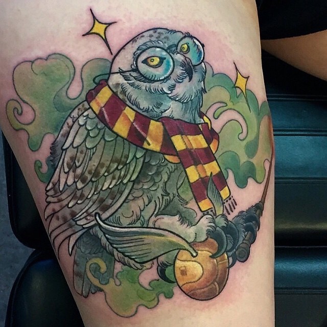 Funny painted cartoon like colored Harry Potter themed tattoo with wise owl and ball with wings