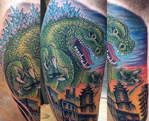 Funny painted colored big Godzilla with city tattoo on leg