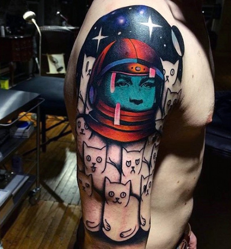Tatuaje en el brazo, astronauta con rostro azul y un montón de gatos