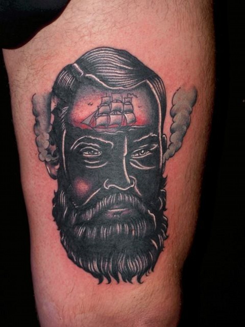 Tatuaje en el muslo,  rostro negro de un hombre con barco en la frente