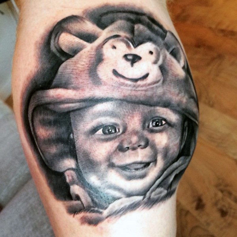 divertente foto realistico bimbo sorridente tatuaggio su gamba