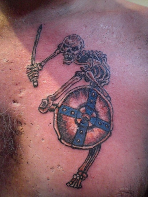 Lustiges Skelett mit Schwert und Schild farbiges detailliertes Brust Tattoo
