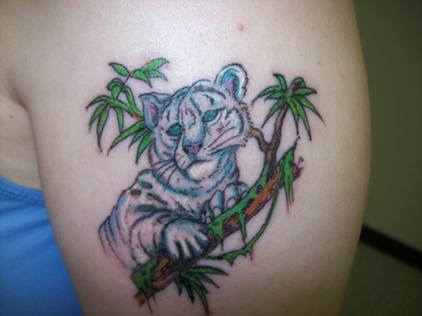 Funny tiny cartoon like colored shoulder tattoo of white tiger baby on tree