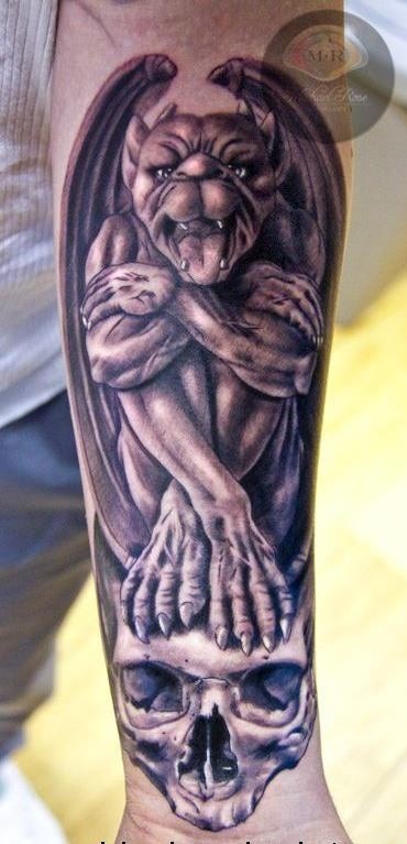 Gargoyle sitzt auf Schädel Unterarm Tattoo