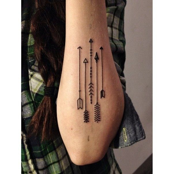 Geometric arrow tattoos on left elbow
