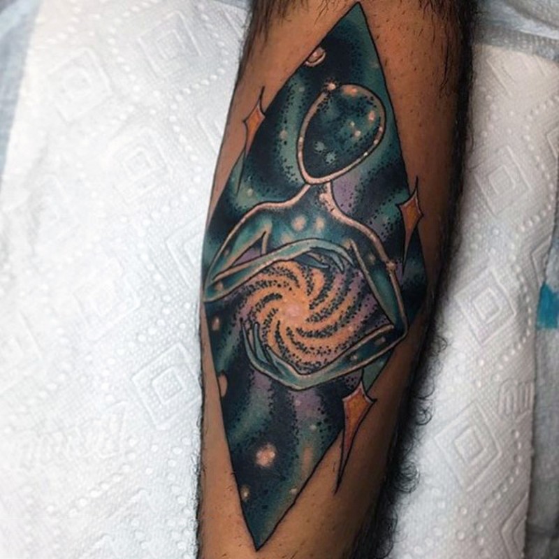 Tatuaje en el antebrazo, extraterrestre extraño con cosmos oscuro