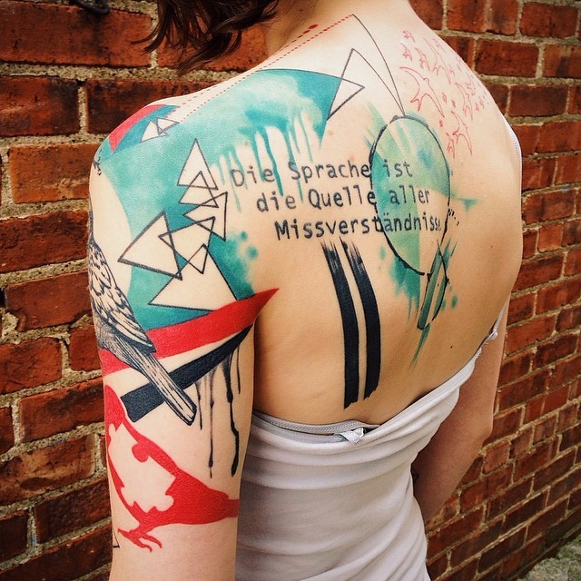 Geometrical colored scapular tattoo of various figures with lettering by Dino Nemec