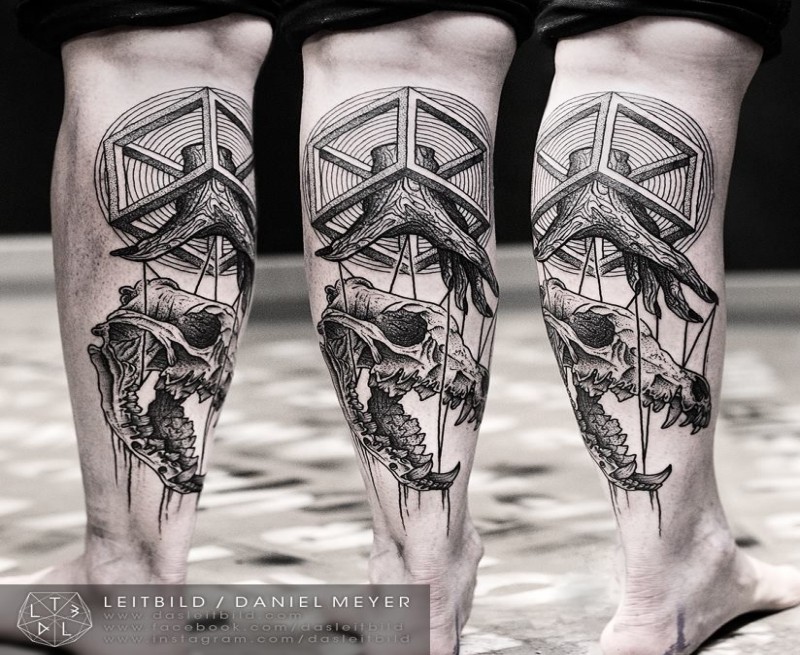 Geometrical style black ink leg tattoo of animal skull with wooden hand