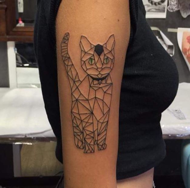 Geometrical style black ink shoulder tattoo of cat with green eyes