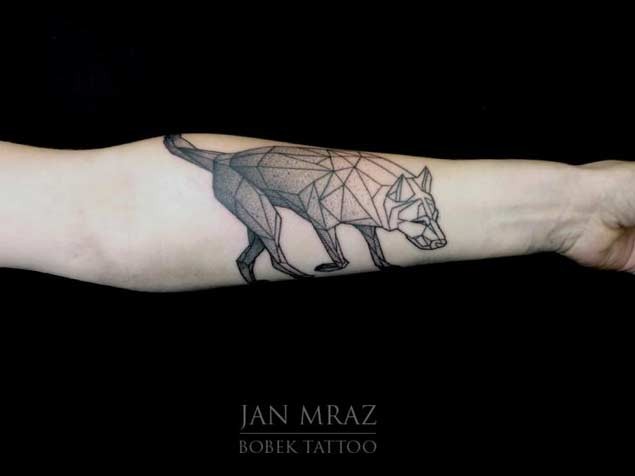 Geometrical style black ink wolf like tattoo on forearm zone