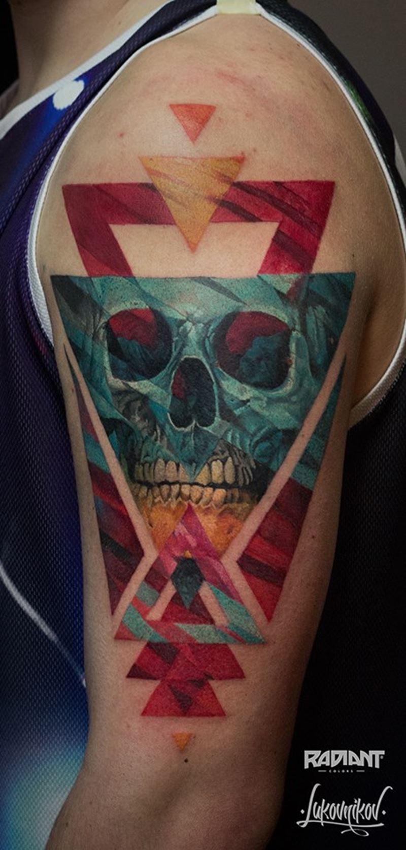 Geometrical style colored shoulder tattoo of triangles and skull