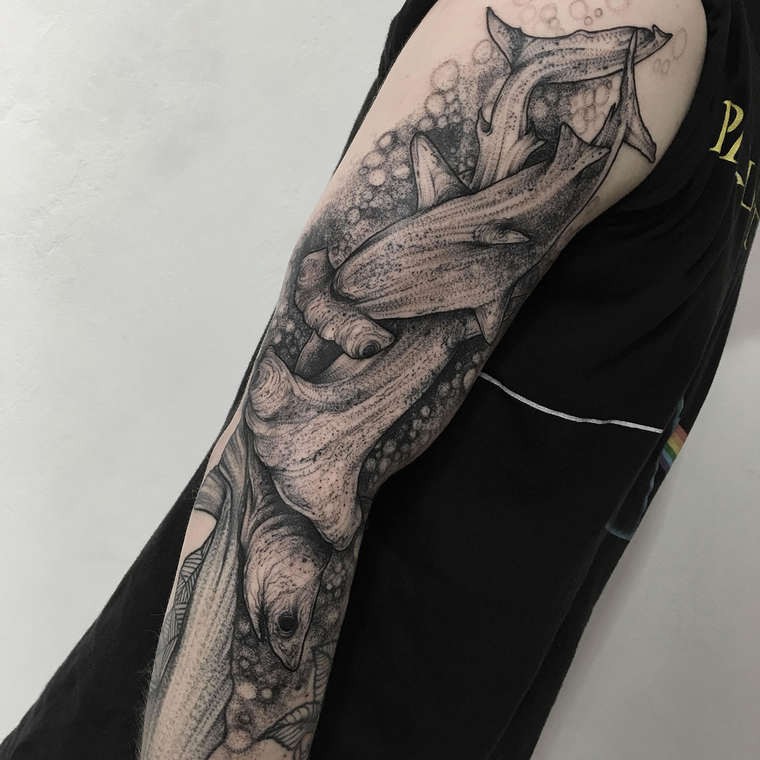 Gorgeous 3D like black ink sleeve tattoo of underwater hummer sharks