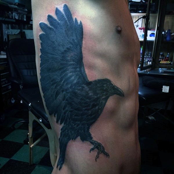 Gorgeous black ink detailed flying crow tattoo on side