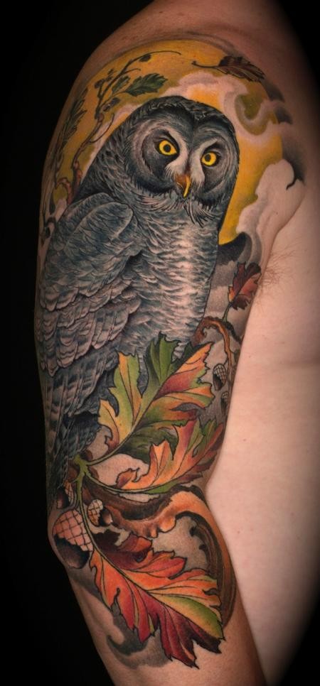 Gorgeous lifelike colored creepy owl tattoo on half sleeve with oak leaves and acorns