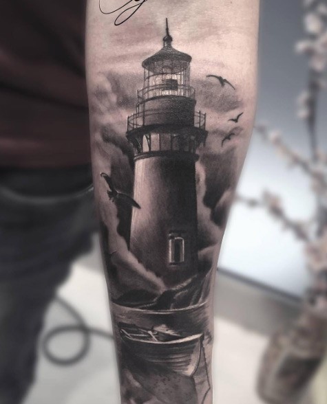 Gorgeous looking black and white old lighthouse tattoo on forearm with boat and seagulls