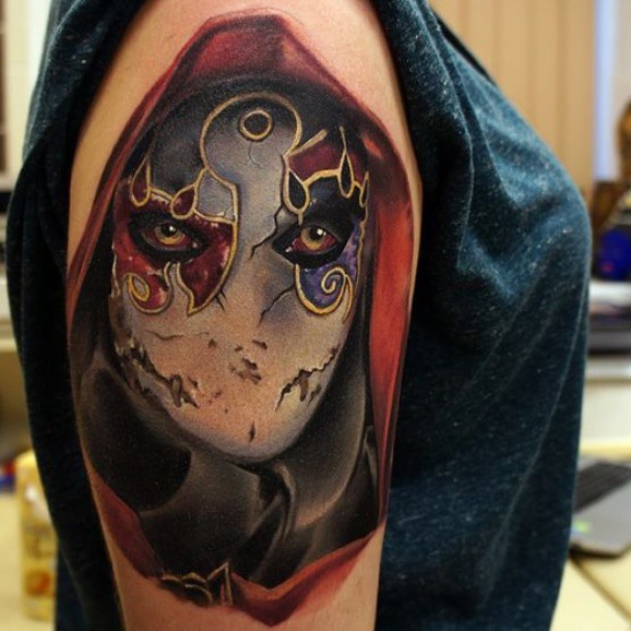 Gorgeous painted big colorful mystical masked person tattoo on shoulder