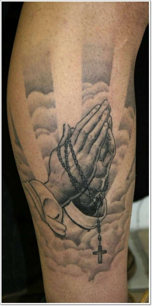 Gorgeous painted detailed praying hands with cross and sky tattoo on arm