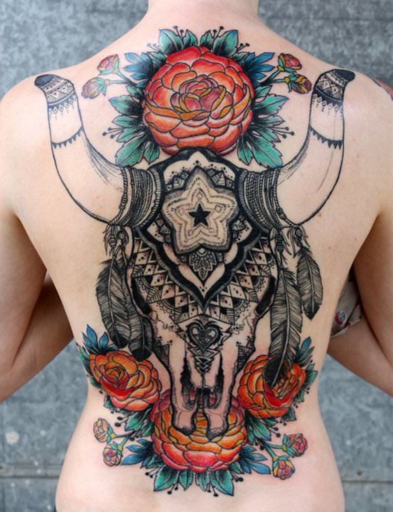 Tatuaje en la espalda, cráneo masivo de toro con flores diferentes y plumas