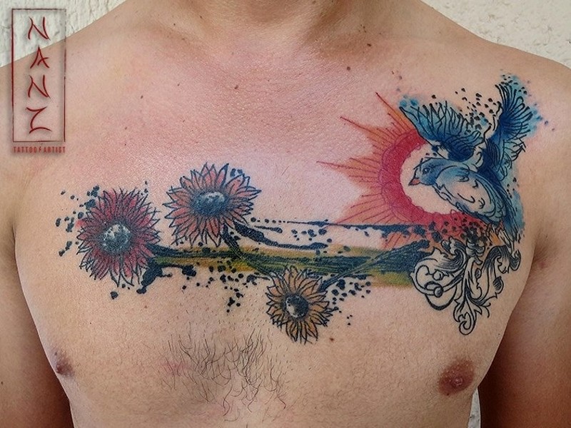 Gorgeous watercolor style painted wildflowers tattoo on chest combined with nice flying bird