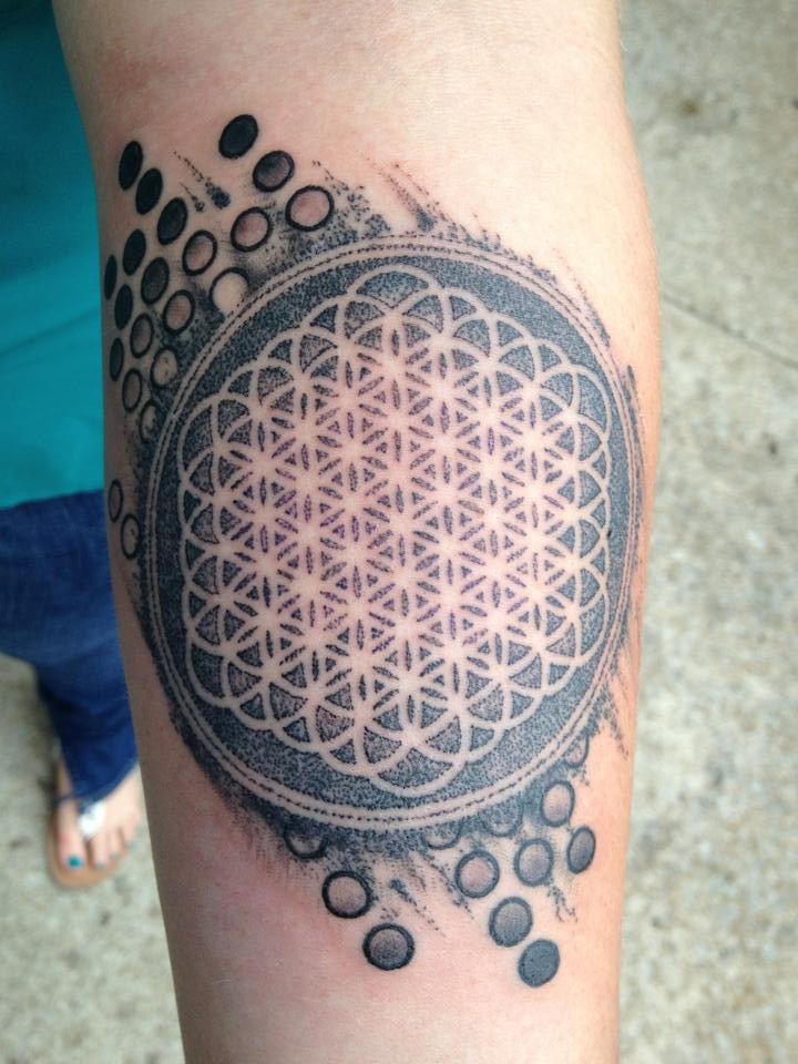 Gray-ink flower of life with ornaments tattoo on arm