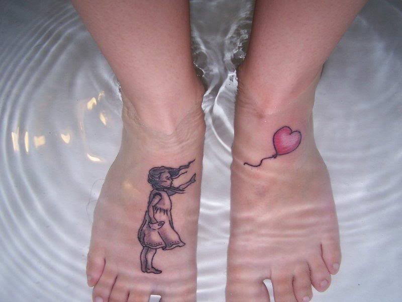 Tattooes von einem Mädchen in grauer Tusche und einem Herzen auf  Füßen