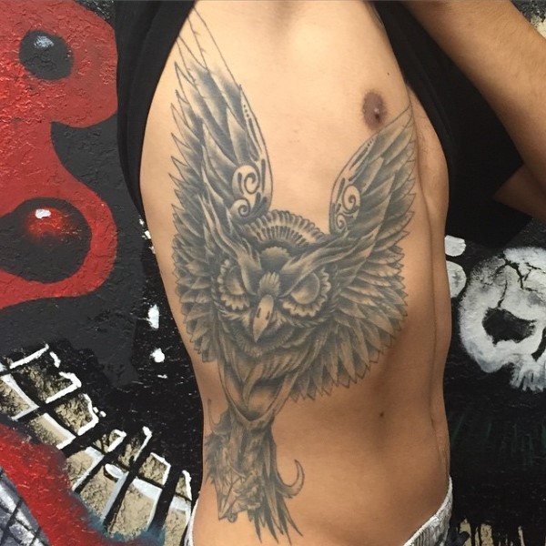 Gray ink stylized flying big owl tattoo on thigh