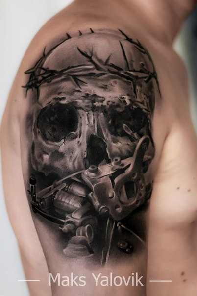 Gray washed style detailed shoulder tattoo of human skull with vine