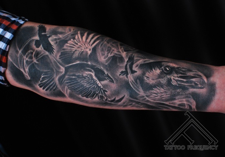 Gray washed style forearm tattoo of various crows