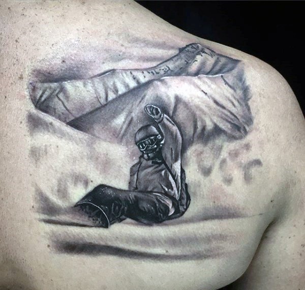 Gray washed style scapular tattoo of snowboarder with mountains