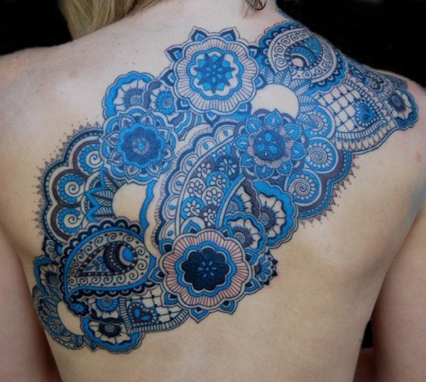 Great blue colored floral tattoo stylized with different ornaments on upper back