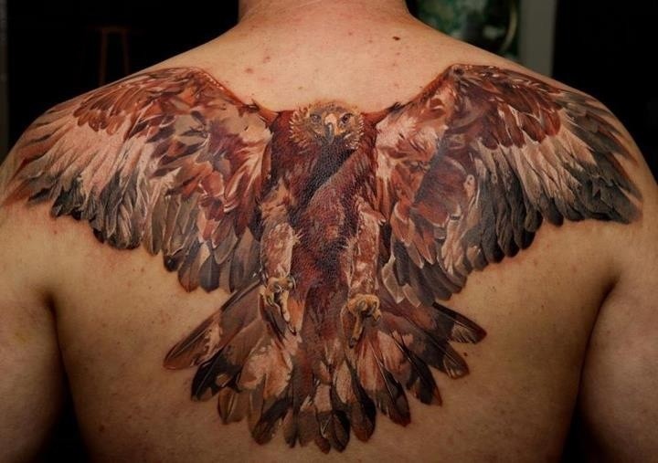 Great colorful flying eagle tattoo on upper back