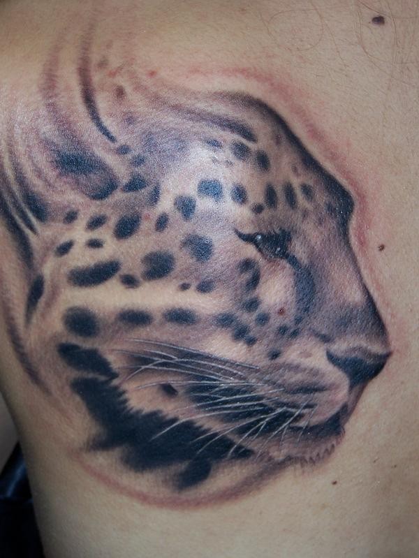 Tatuaje en la espalda,
cabeza de guepardo divino de perfil