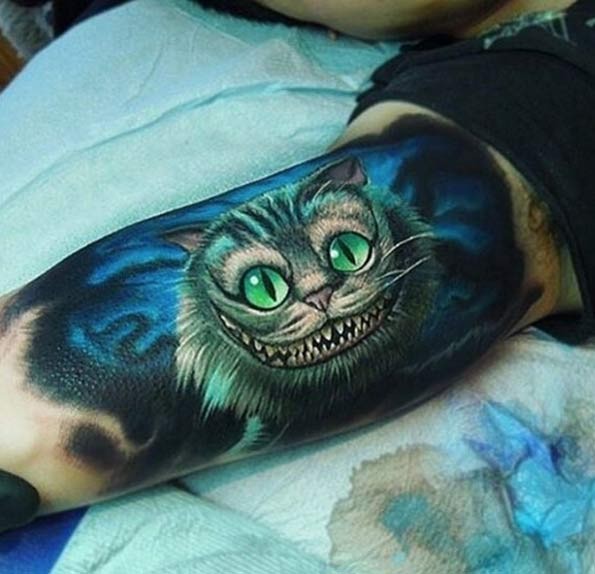 Great looking colorful Cheshire cat tattoo on biceps