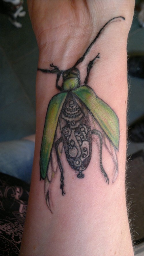 scarabeo verde biomeccanica tatuaggio sul polso
