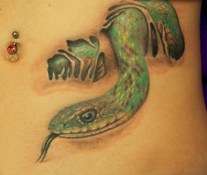 Green snake crawls out of skin tattoo
