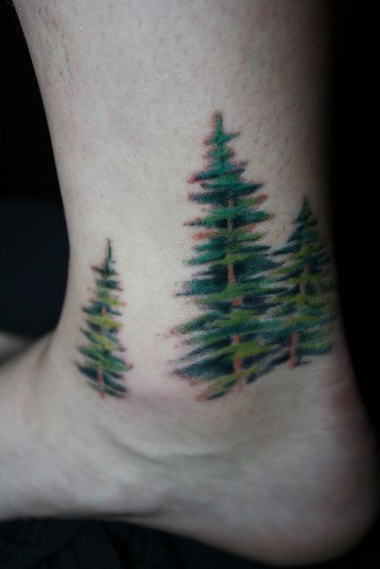 Tattoo mit grünen Fichten am Fuß